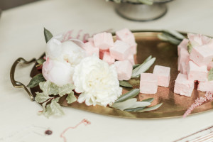 a brass art nouveau tray with pink marshmallows and white flowers