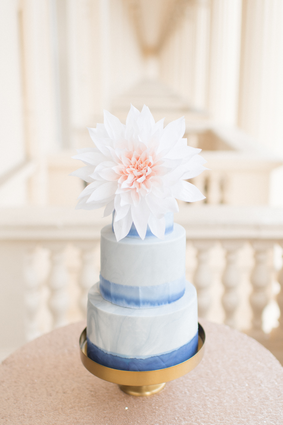 a 3 tier grey and white marble wedding cake with blue watercolour silk ribbon and a large statement paper cafe au lait dahlia at The Institute of Contemporary Arts