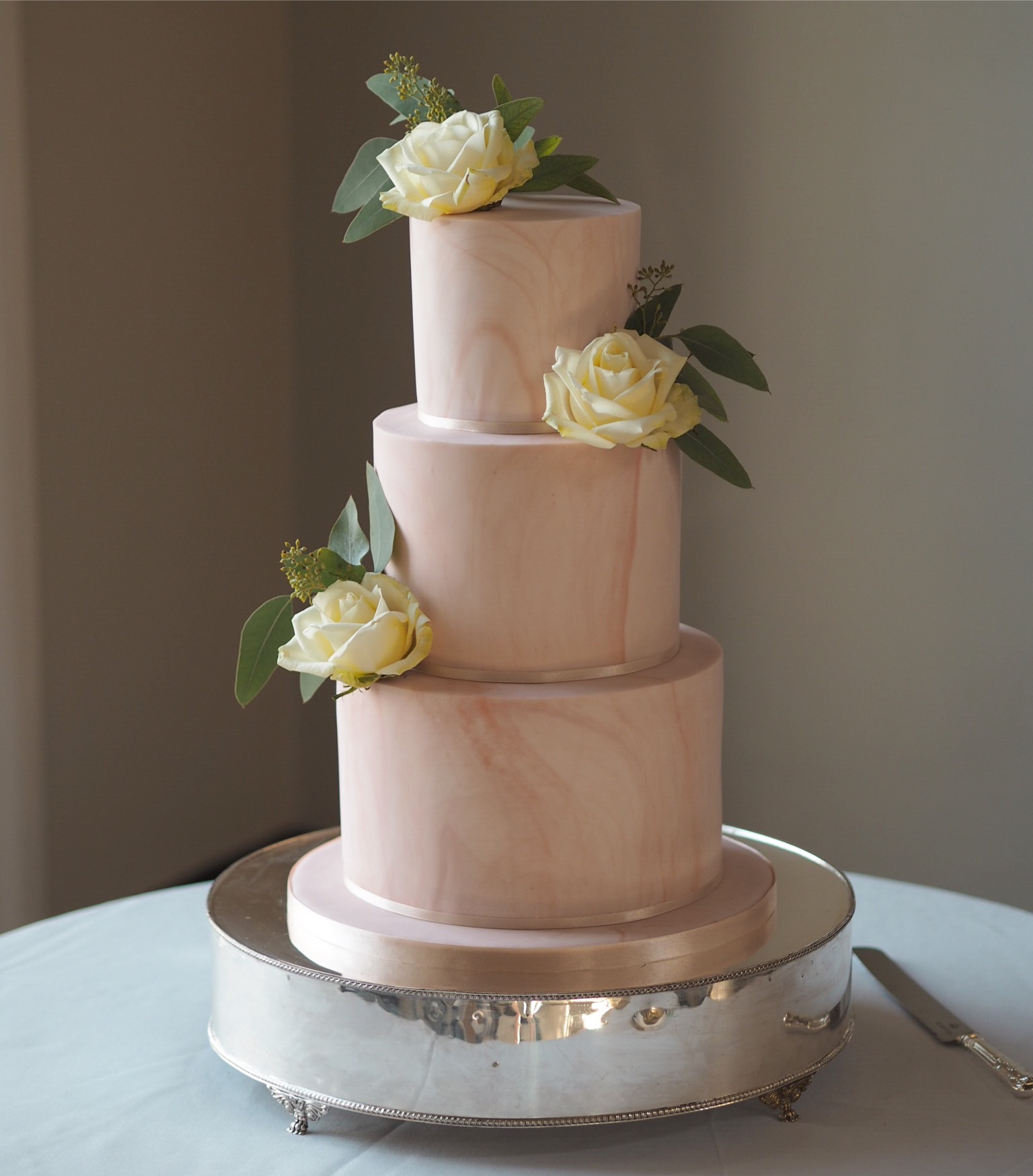 a blush marble 3 tier wedding cake with ivory roses and eucalyptus at the Queen's House wedding venue Greenwich