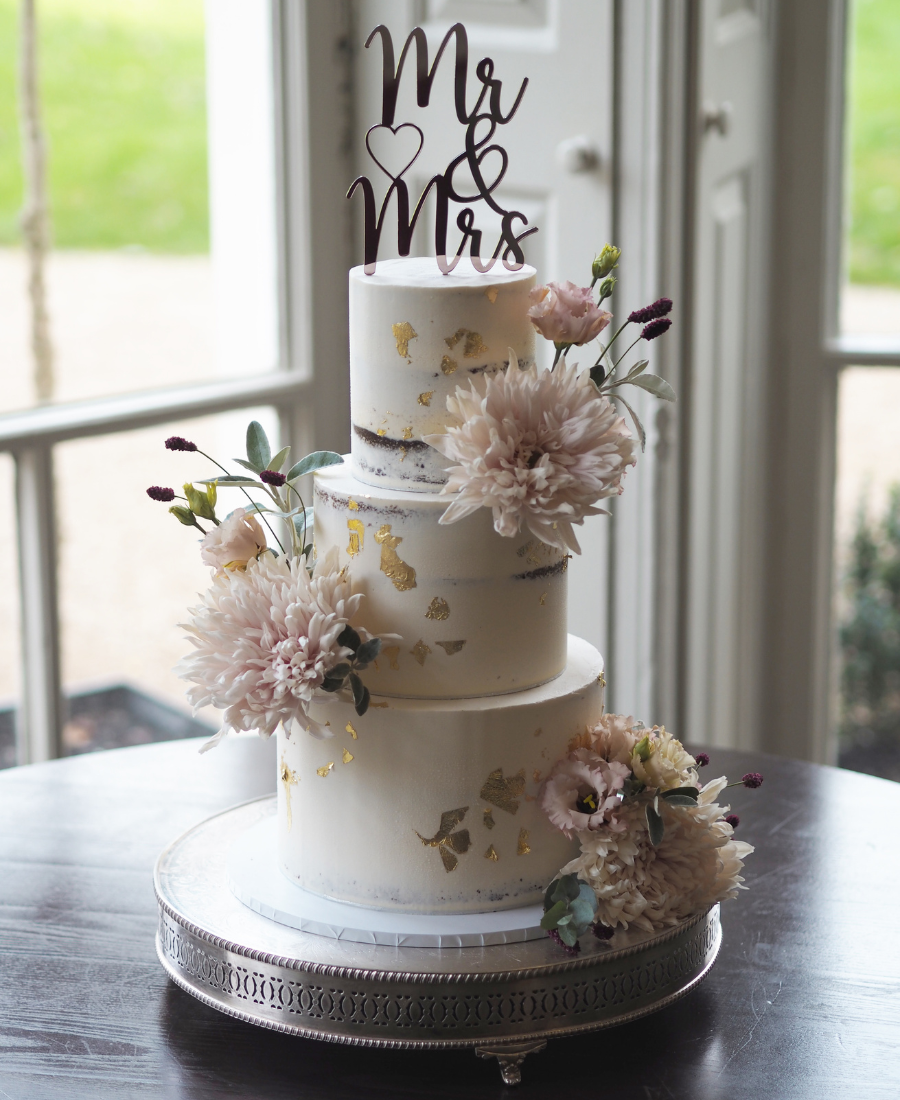a 3 tier semi-naked wedding cake with gold leaf and fresh flowers at Morden Hall weddings